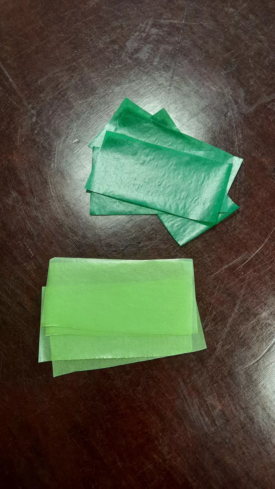 Acht grüne Rechtecke aus Transparentpapier in zwei Farbtönen