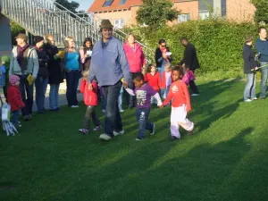 Kinder und Erwachsene spielen gemeinsam auf einer Wiese